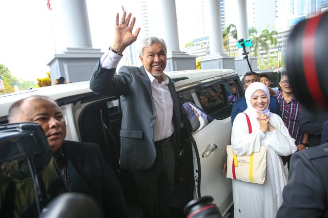 Ahmad Zahid Hamidi Court Discharge Ahmad Zahid Hamidi, flanked by lawyers, leaves court after judge grants discharge on 47 corruption charges.