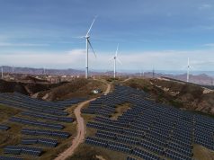 China Clean Power Capacity Surpasses Fossil Fuels Solar panels and wind turbines stretch across a Chinese landscape, symbolizing the country's growing renewable energy capacity.