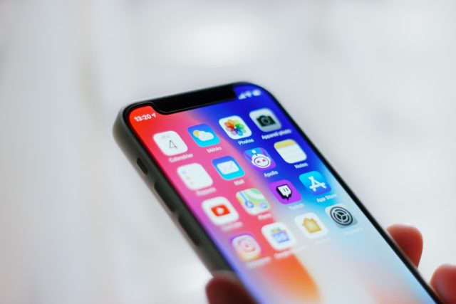 Apple’s AI system excludes Intel-based Macs from support A MacBook with an Intel sticker on the palm rest sits next to an iPhone displaying the Apple Intelligence interface.