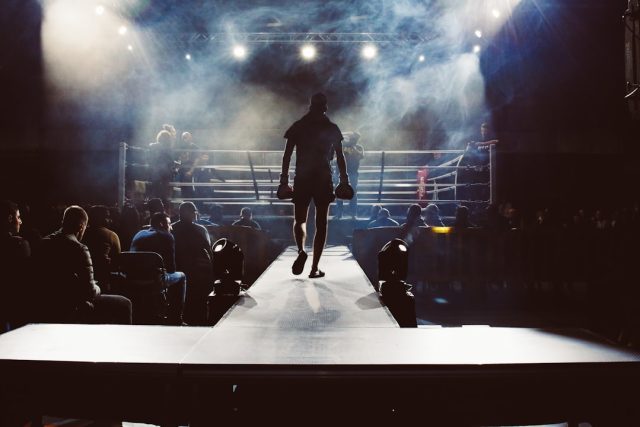 Lauren Price Unifies Welterweight Division with Five Titles in One Fight Lauren Price in a boxing ring wearing championship belts after unifying the welterweight division.