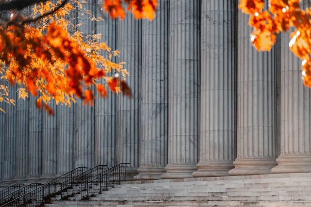 Sam Bankman-Fried Sentenced to 25 Years for FTX Fraud and Conspiracy Sam Bankman-Fried stands in a courtroom in a suit, facing sentencing for FTX fraud charges.