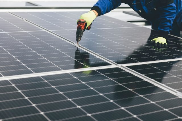 UK solar hits record 15,420 megawatts, raising questions on energy storage Solar panels on a rooftop under a bright blue sky, generating electricity on a sunny afternoon.