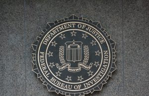 FBI Releases 2025 UAP Photo With No Date or Location Grainy monochrome military photo showing crosshairs and a small dark circle above a blurred mountain range.