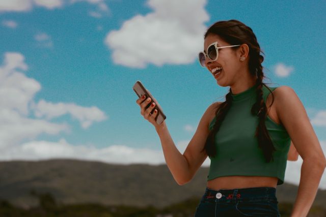 Musk's Grok chatbot launches on app stores with deep understanding claim A smartphone screen displays the Grok chatbot interface, with a Tesla Optimus robot visible in the background.