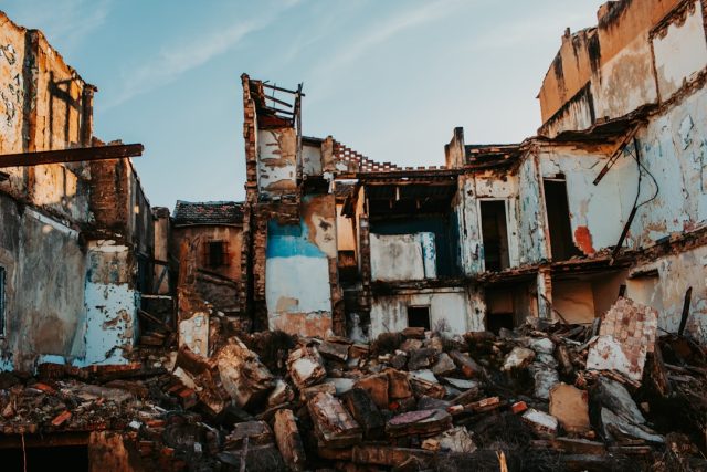 Herat Region Aftershock Kills One, Injures 65, Underscoring Ongoing Danger Collapsed mud-brick homes in a Herat village with rescue teams searching debris under a dust-filled sky after the 6.3 aftershock.