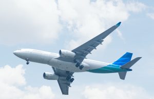 FAA Grounds Boeing 737 Max 9 After Door Plug Failure A Boeing 737 Max 9 aircraft parked on a tarmac with maintenance crew inspecting the fuselage near the door plug area.