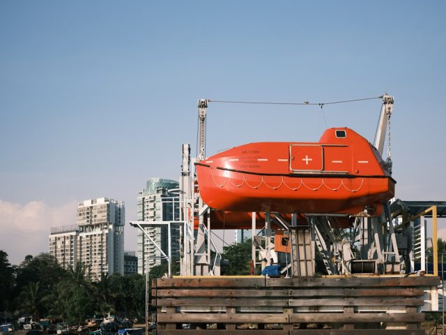 German NGO Rescues 59 Survivors, Recovers Three Bodies from Tiny Dinghy Overcrowded gray inflatable dinghy adrift on open sea as orange rescue vessel approaches