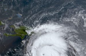 Hurricane Beryl Death Toll in Texas Hits 22 Aerial view of a flooded neighborhood in Texas after Hurricane Beryl, with downed power lines and debris scattered across residential streets.