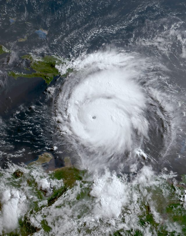 Hurricane Beryl Death Toll in Texas Rises to 22 People Aerial view of a flooded neighborhood in Texas after Hurricane Beryl, with downed power lines and debris scattered across residential streets.