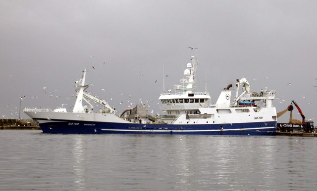 Fishing Trawler Capsizes Off South Korea's Jeju Island, Five Missing A capsized fishing trawler floats in rough seas off Jeju Island as coast guard boats approach for rescue operations.