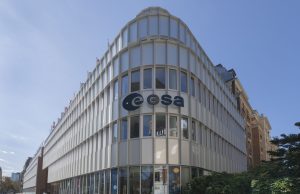 ESA Lowers Asteroid 2024 YR4 Impact Risk to 1.5% European Space Agency headquarters in Paris with staff monitoring asteroid 2024 YR4 trajectory on screens.
