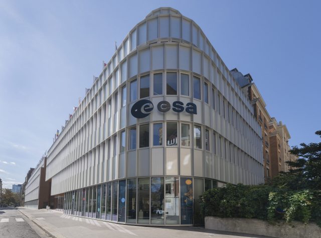 European Space Agency Lowers Asteroid Impact Probability to 1.5 Percent European Space Agency headquarters in Paris with staff monitoring asteroid 2024 YR4 trajectory on screens.
