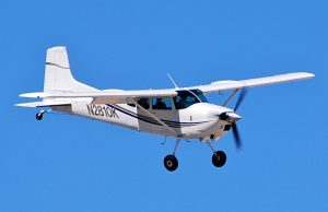 Cessna 180 Crash Kills Three in Nebraska River Rescue boats circle a partly submerged white Cessna 180 in the muddy Platte River as crews work along the wooded bank under gray skies.