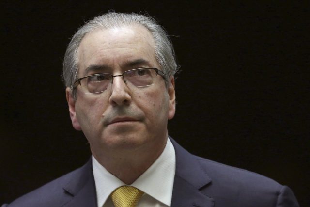 Eduardo Cunha Corruption Conviction Eduardo Cunha speaking at a podium in the Brazilian Chamber of Deputies during a legislative session.
