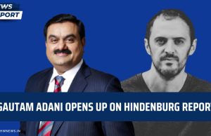 Adani Controversy Unresolved After Hindenburg Report Gautam Adani speaking at a business conference, with the Adani Group logo visible in the background.