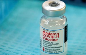 Moderna Ships First Coronavirus Vaccine for Testing A scientist in a lab coat holds a vial labeled mRNA-1273, the Moderna coronavirus vaccine, ready for shipment to NIAID for clinical testing.