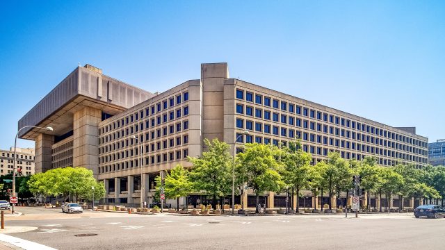 Pentagon Building A grainy monochrome image with a central crosshair shows two small dark circular objects in the upper right quadrant, submitted by the FBI to the Pentagon's UAP office.