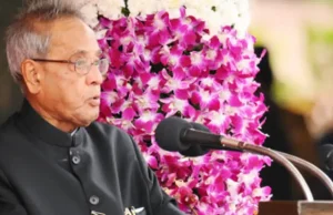 Ex-Indian President Alarmed by Bank Scandal Surge Pranab Mukherjee speaking at a podium in Kolkata, expressing concern over corporate frauds