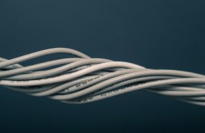 Sarawak Cable Cuts Kuching-Singapore Latency to 30ms Technicians inspect fiber optic cables on a spool near a coastal landing station in Sarawak.