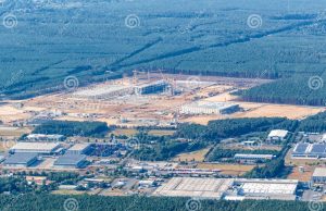Tesla Builds First European Gigafactory Near Berlin Protesters holding signs and blocking a road near a forested area in Brandenburg, Germany, opposing Tesla's planned factory construction.