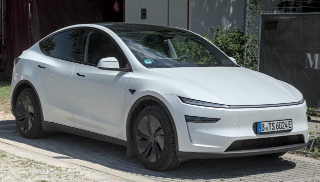 Tesla Robotaxi A Tesla vehicle with Full Self-Driving software drives through Austin streets with a safety monitor in the front passenger seat.