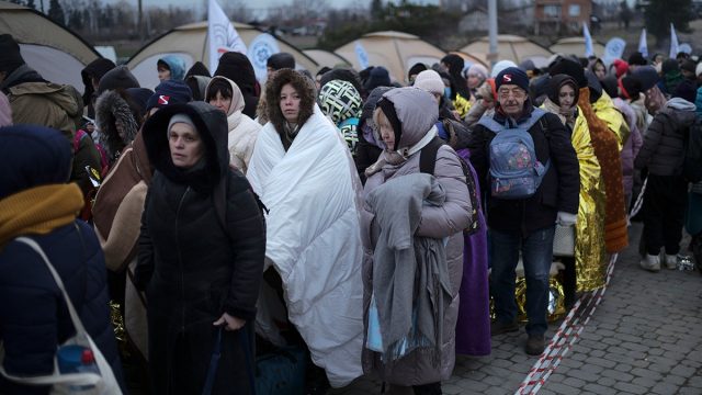 Ukraine Refugees Lviv March 2022 Ukrainian refugees carrying bags cross a border checkpoint into eastern Europe, fleeing Russian strikes in western Ukraine.