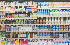 UN Report Confirms 2022 Global Food Prices Hit Record Highs A crowded market stall with empty shelves and a shopper examining a single bag of grain, reflecting food scarcity during record price highs.