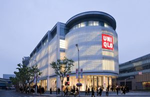 Uniqlo Reopens 720 of 750 China Stores Customers wearing masks stand in line at a Uniqlo store in Shanghai with social distancing markers on the floor.