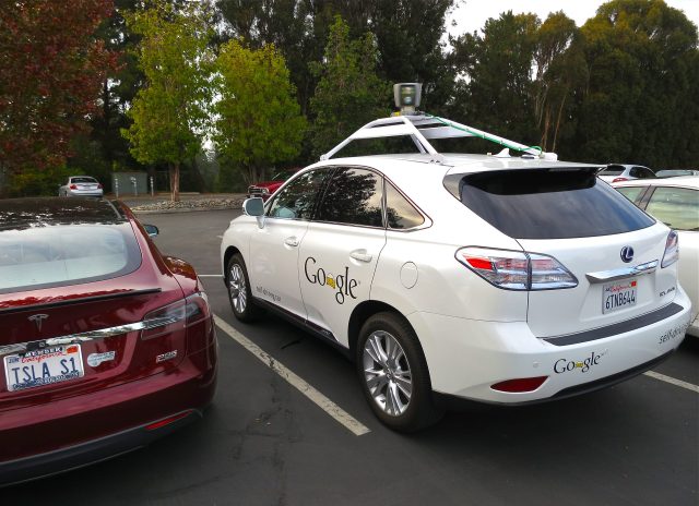 Waymo A Waymo autonomous vehicle drives on a city street with passengers inside