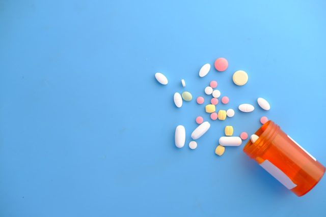 FDA Approves Capivasertib Pill for HR-Positive, HER2-Negative Breast Cancer A healthcare professional holds a bottle of Truqap pills beside a patient in a clinic exam room.