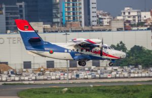 Pentagon Report Reveals Russian Jet at Iraq Base A military surveillance aircraft flies over a desert airbase with runway lights visible below.
