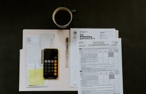 Malaysia Ends Tax Break for Corporate Fund Investors Fund managers reviewing documents at a desk in Kuala Lumpur, preparing for the tax exemption expiry deadline.