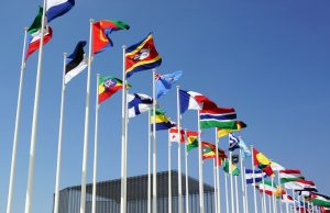 US Seeks 140-Country Bloc to Suspend Russia from UN Rights Council U.S. diplomats huddle at UNGA desks counting yellow vote cards while Russian seat sits empty in Geneva council chamber.
