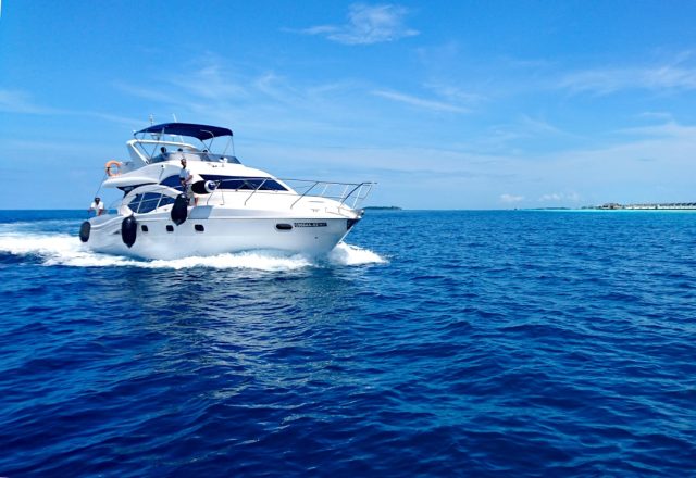 Haitian Migrant Boat Fire Leaves Families Grieving Across Caribbean A burning migrant vessel at sea near the Turks and Caicos Islands, with rescue boats approaching the smoke-filled scene.