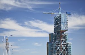 SpaceX Tower Catches Starship Booster in Historic Test SpaceX launch tower mechanical arms gripping a descending rocket booster at Starbase in Texas